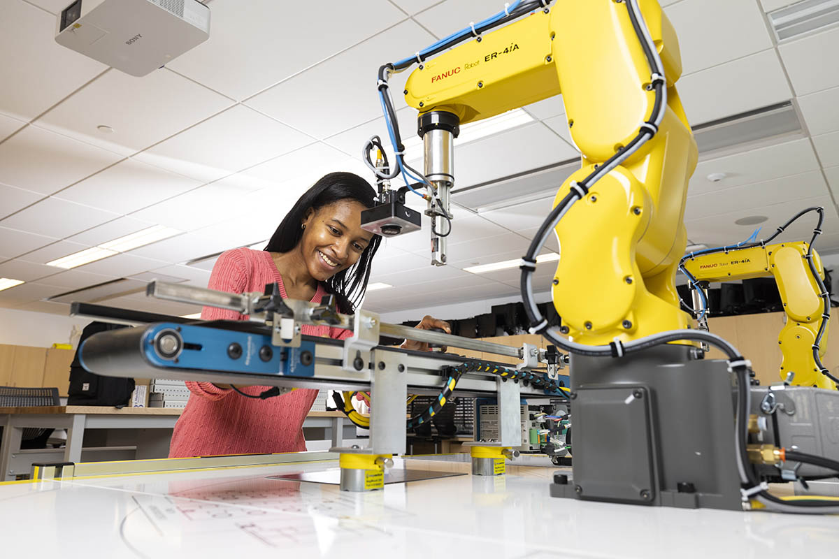 A student works on a robotic arm.
