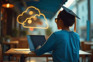 A photo from behind of a young african american woman sitting at a table in a coffee shop. She is wearing a graduation cap and looking at a laptop. there are neon cloud icons above her.