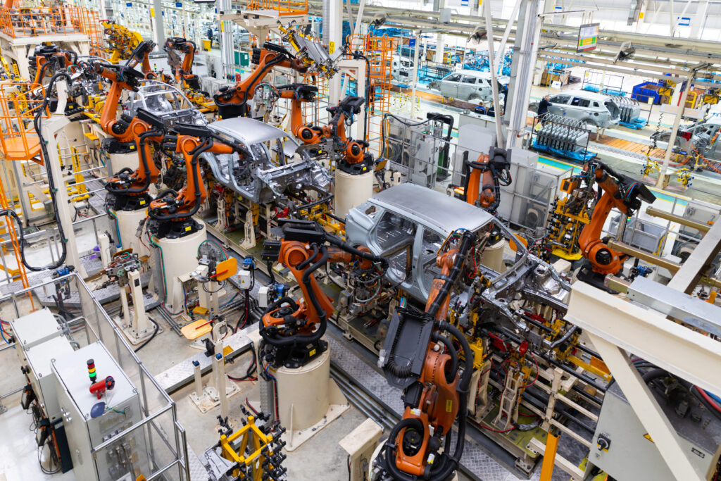 A large assembly line with robotic arms assembling vehicles.