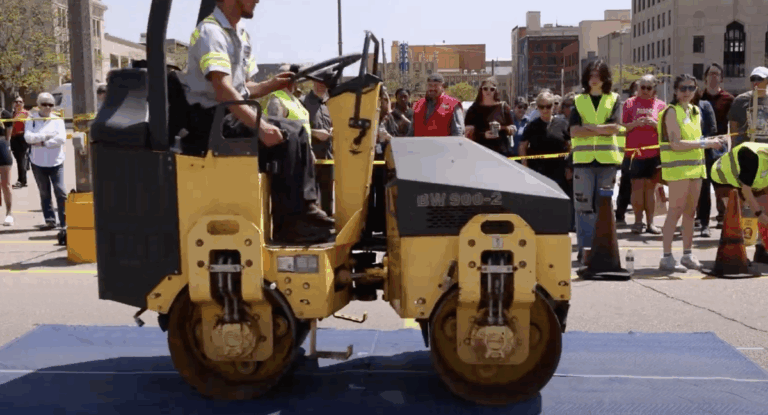 A steamroller rolling over a covered print of art