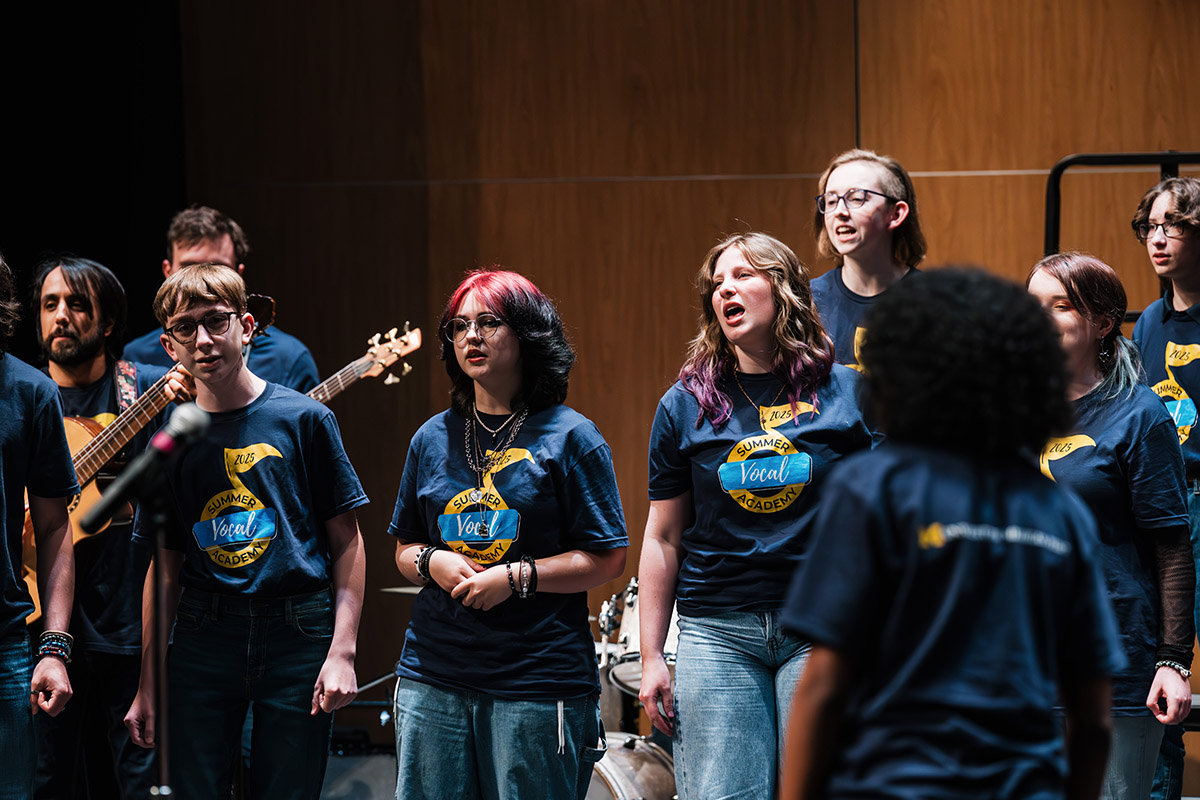 A group of vocalists performing ons tage.