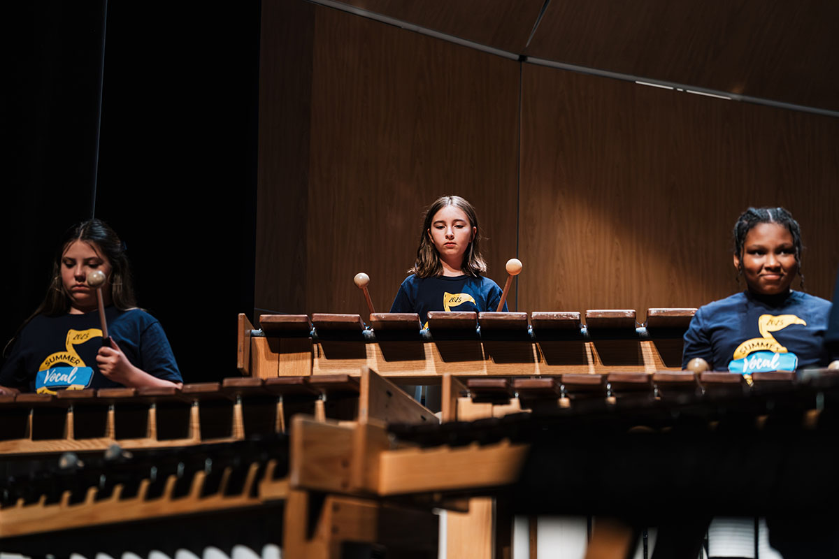 Summer Vocal Academy of Music campers playing a percussion instrument like a xylophone.