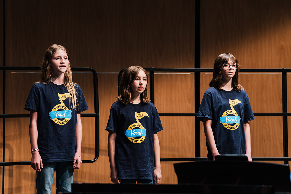 Three vocalists performing.