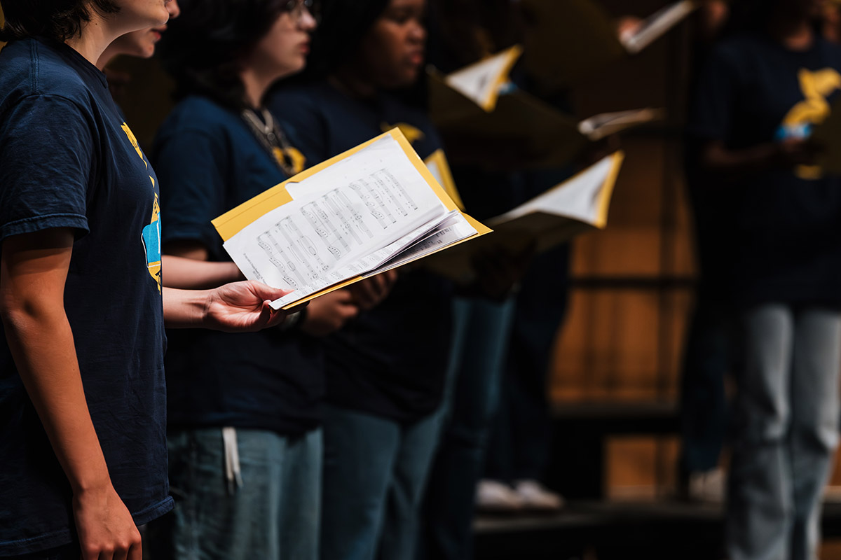 A close up of the sheet music being held by vocalists