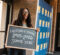 Smiling student holds a chalkboard sign marking the first day of senior year, 2025–2026.