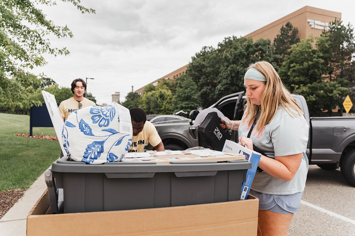 A UM-Flint student volunteer loading totes