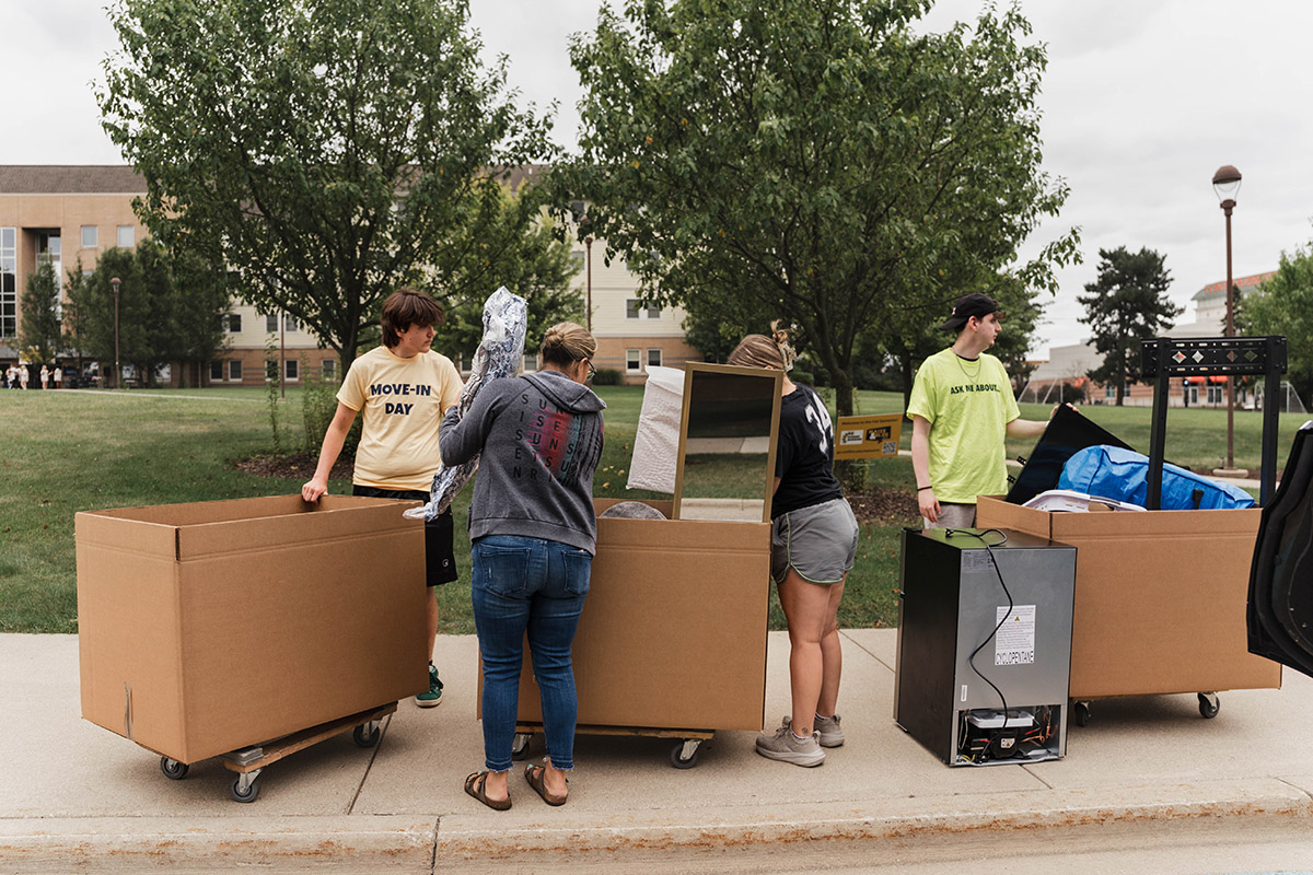 Large cardboard boxes of belongings on totes outside of First Street Residence Hall