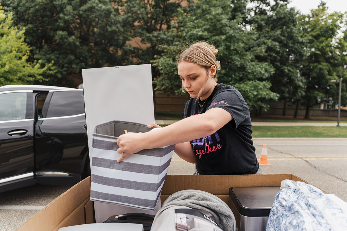 A student loading her belongings into a cart