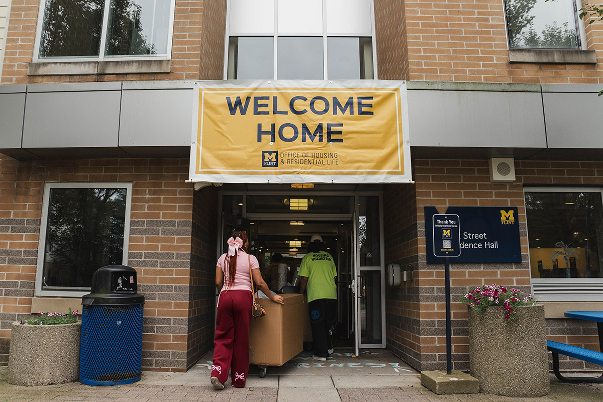 A sign hanging above the entrance to First Street Street Residence Hall that says Welcome Home