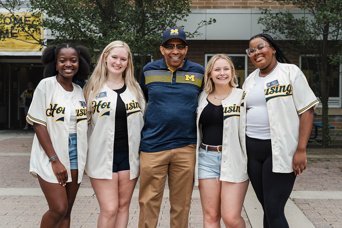 Chancellor Laurence Alexander posing for a photo with student volunteers.