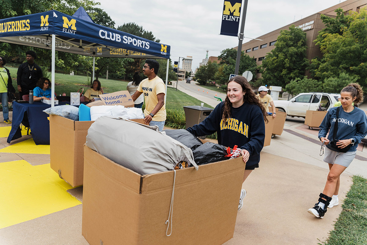 UM-Flint students carting their belongings inside.