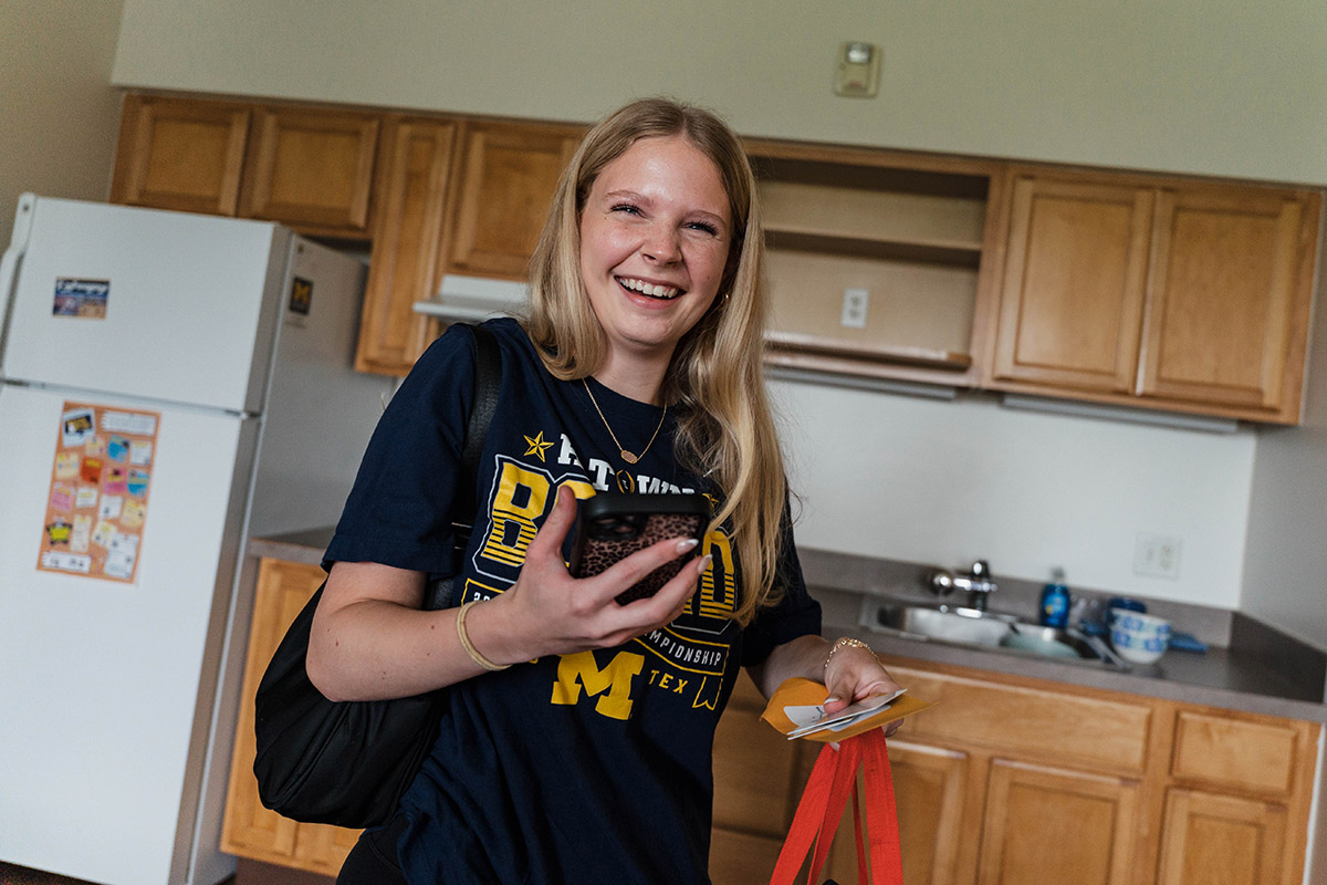 A student smiles for the camera inside her new dorm