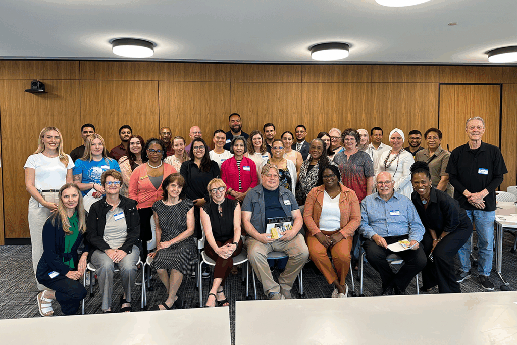 A group photo of the community launch event, featuring people seated and smiling at the camera
