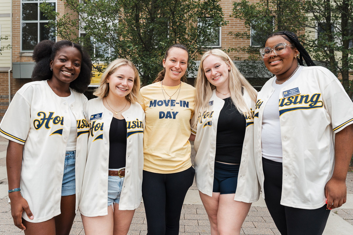 A group of Move-in Volunteers in Maize and Blue Baseball jerseys in front of First Street Residence Hall