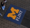 An overhead view of the first floor of the University Center with students walking close to a UM-Flint stamp logo on the floor.