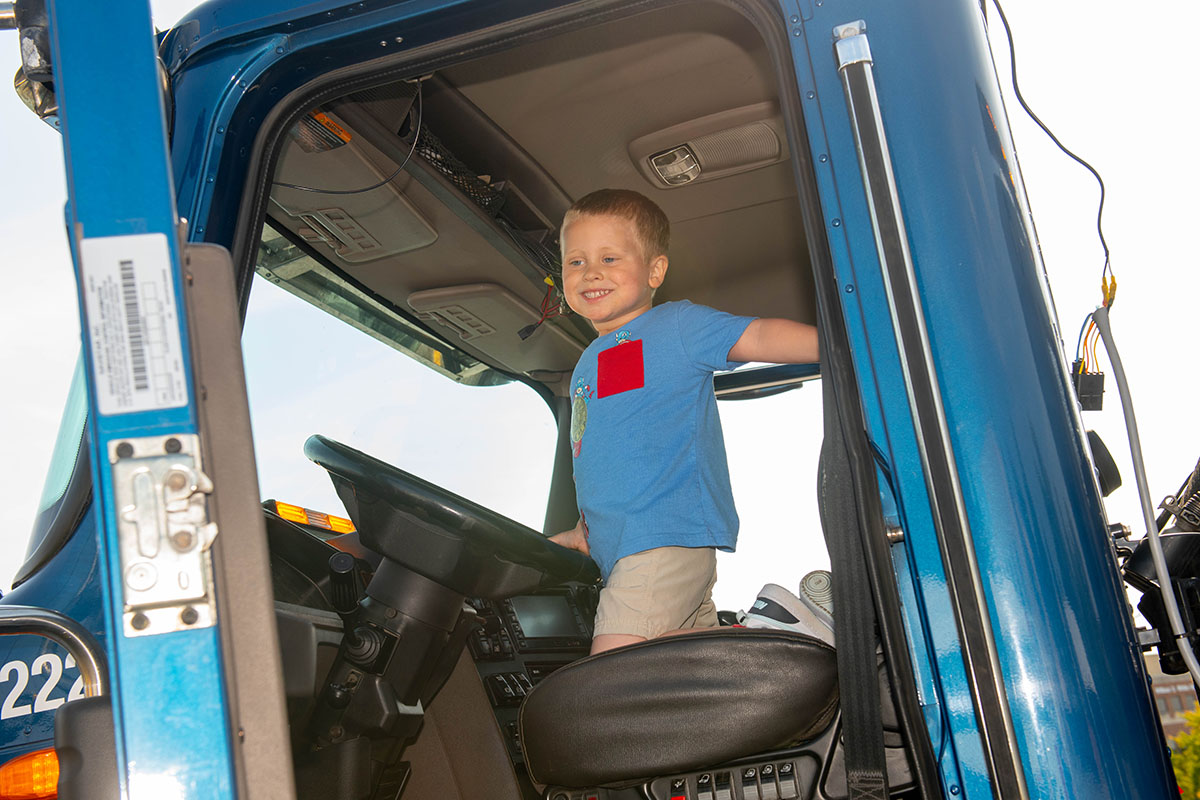 A young boy in the driver's seat of a truck