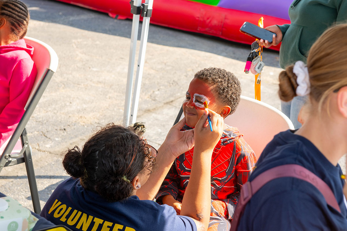 A young attendee getting his face painted