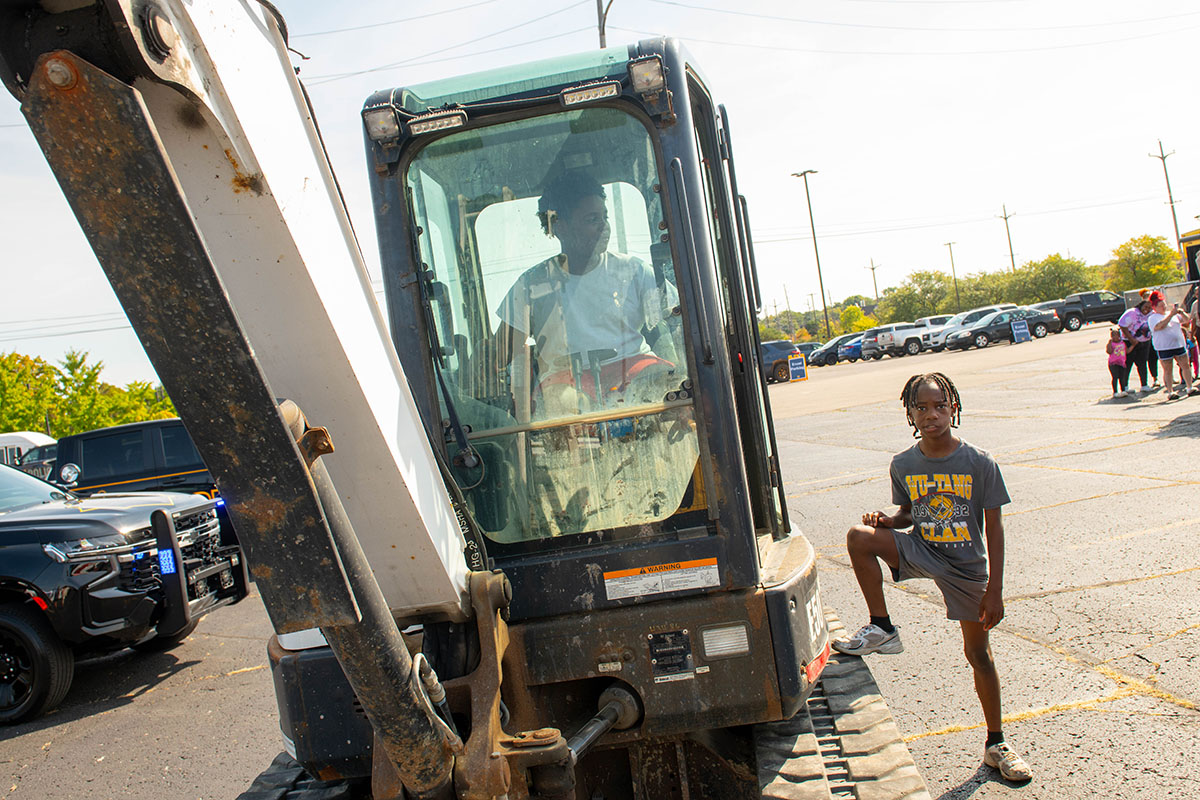 A young boy sitting in the driver's seat of a crane truck