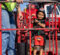 A young boy is flexing his muscles while wearing a fireman's helmet and standing in a cherry picker bucket