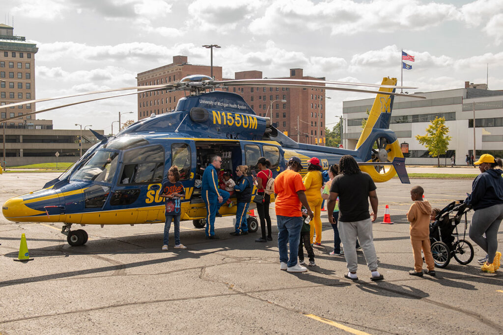 The University of Michigan survival flight helicopter with families lined up to see inside. 