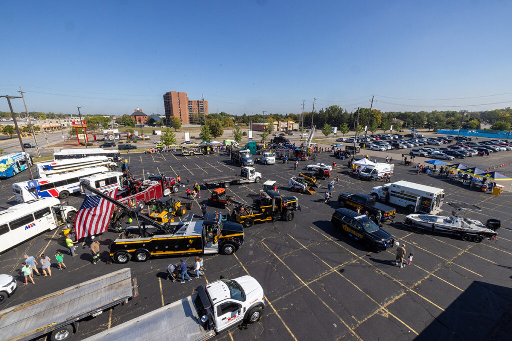 An aerial photo of a parking lot filled with emergency vehicles and utility trucks