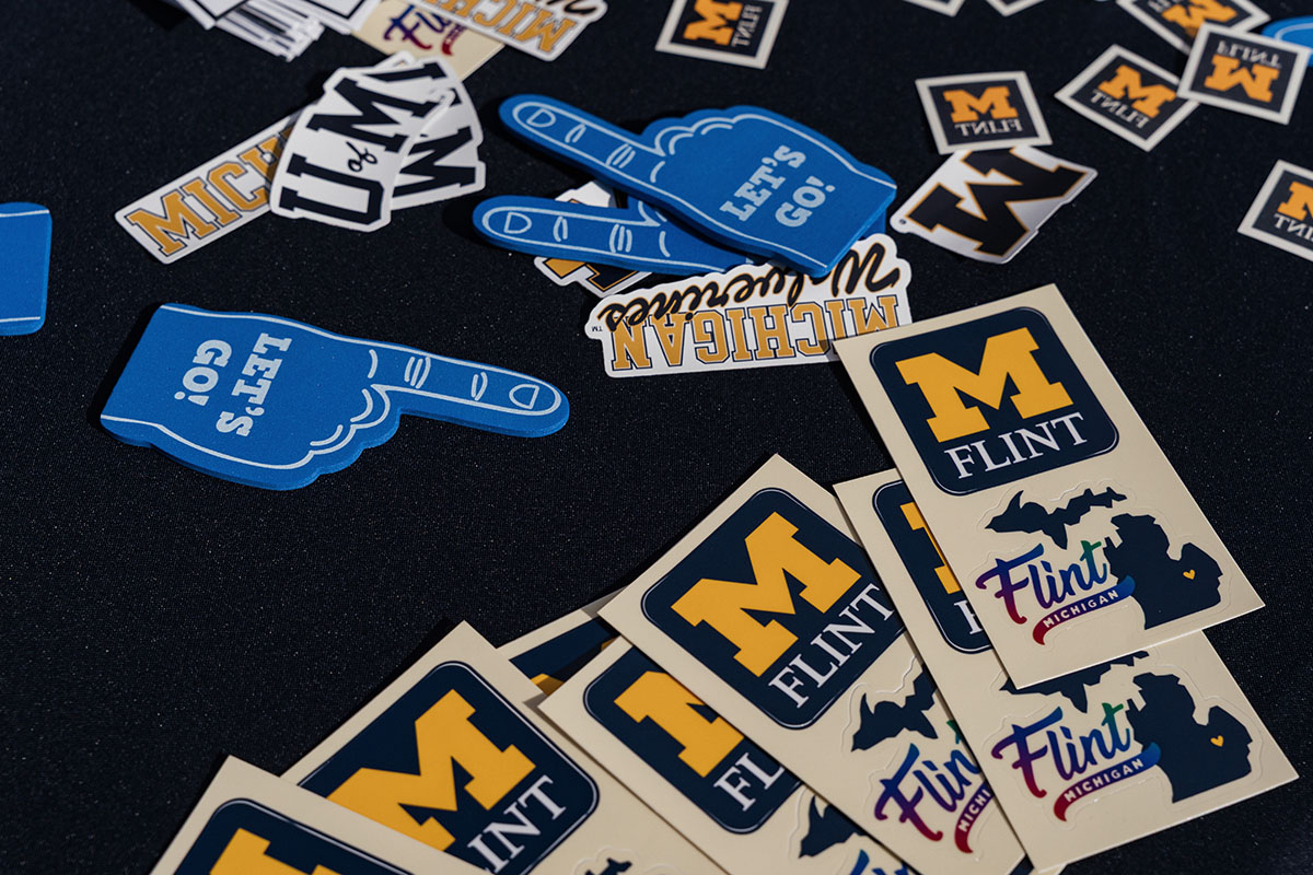 A collection of stickers featuring blue foam fingers with "LET'S GO!", "M FLINT", and various Michigan-themed designs.