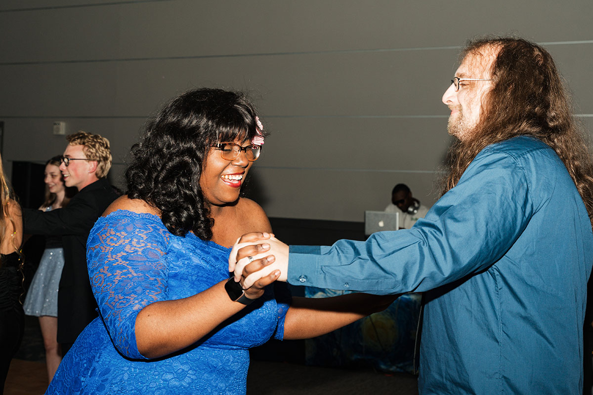 Two people holding hands and dancing.