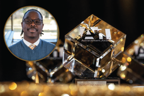 A crystal award with the text "the ATI of Achievement Awards" and "Certified Tourism Ambassador" displayed prominently. Antonio Riggs' photo is overlaid.