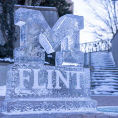A carved ice sculpture of the UM-Flint logo