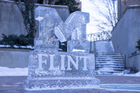 A carved ice sculpture of the UM-Flint logo