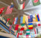 A variety of international flags hanging from the ceiling in a spacious indoor area, showcasing cultural diversity.