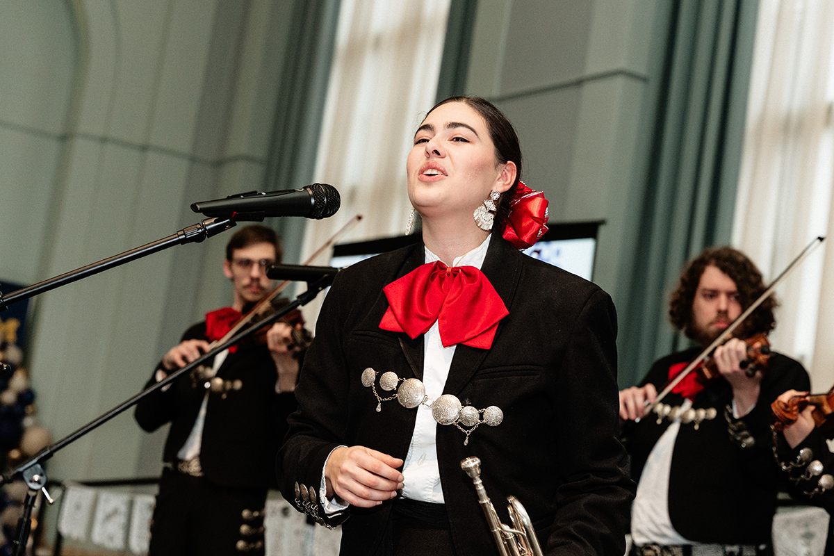 FLINT_Latin Graduation Celebration 2026_0023 Mariachi band members performing, wearing traditional black charro suits with red bow ties and silver decorations.