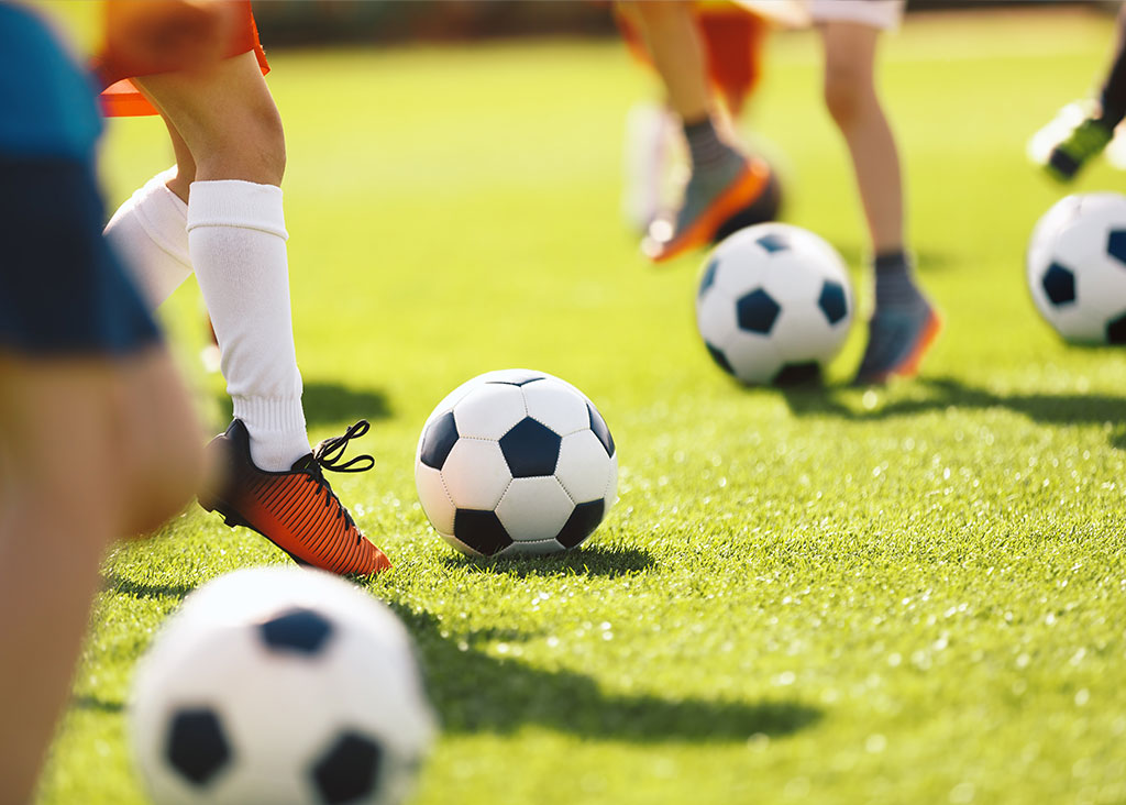 A photo showing the legs of soccer players kicking the ball
