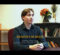 Person sitting at a desk with text overlay reading "Braeden Burger, Computer Science Major, Music Composition Minor, Winter 2026 Maize & Blue Distinguished Scholar," with a bookshelf and flowers in the background and a University of Michigan-Flint logo in the top left corner.