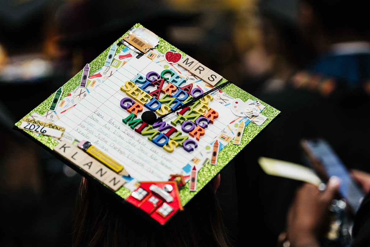 FLINT_Winter Commencement Caps April 2026_0030 Graduation cap decorated with colorful letters spelling "CHAOS GARDENER PLANTING SEEDS FOR GROWING MINDS," school-themed stickers, and "School Year 2026" and "MRS KLANN" labels.