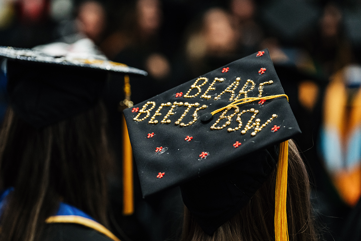 FLINT_Winter Commencement Caps April 2026_0038 Graduation cap decorated with the words "BEARS BEETS BSW" in gold beads and small red bows.