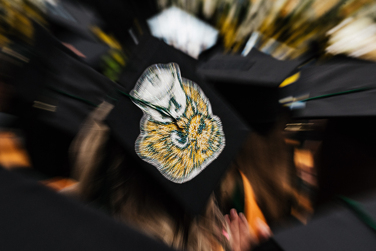 FLINT_Winter Commencement Caps April 2026_0045 Graduation cap decorated with a yellow and white flower design.
