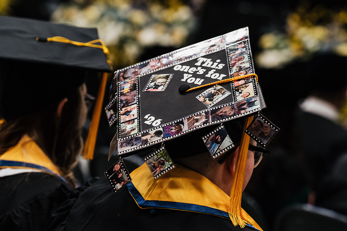 FLINT_Winter Commencement Caps April 2026_0057 Graduation cap decorated with filmstrip-style photos and the text "This one's for you '26" on top.
