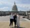 Three people standing in front of the United States Capitol building on a clear day.