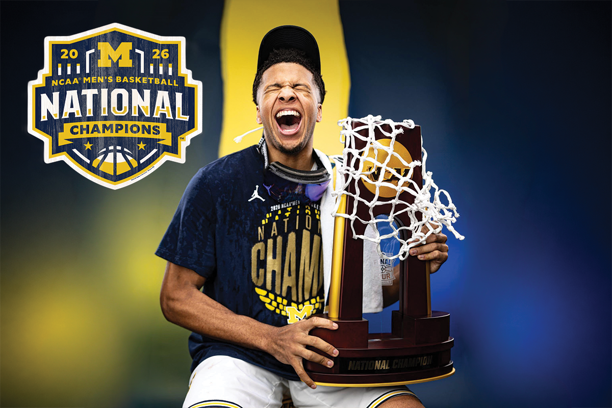 Person holding NCAA Men's Basketball National Champion trophy with 2026 Michigan logo in background.