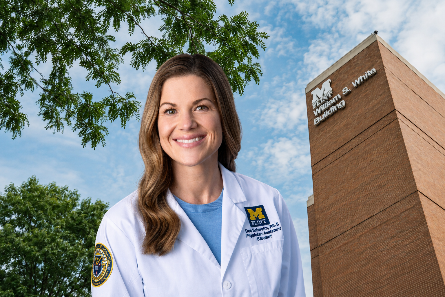 A smiling woman in a white lab coat stands in front of a brick building with the sign "William S. White Building." She has long brown hair and is wearing a blue shirt underneath her lab coat.