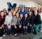 Students from the three-day Pediatric/Adolescent SANE Boot Camp gather in front of a white wall in the William S. White Building with the UM-Flint School of Nursing logo