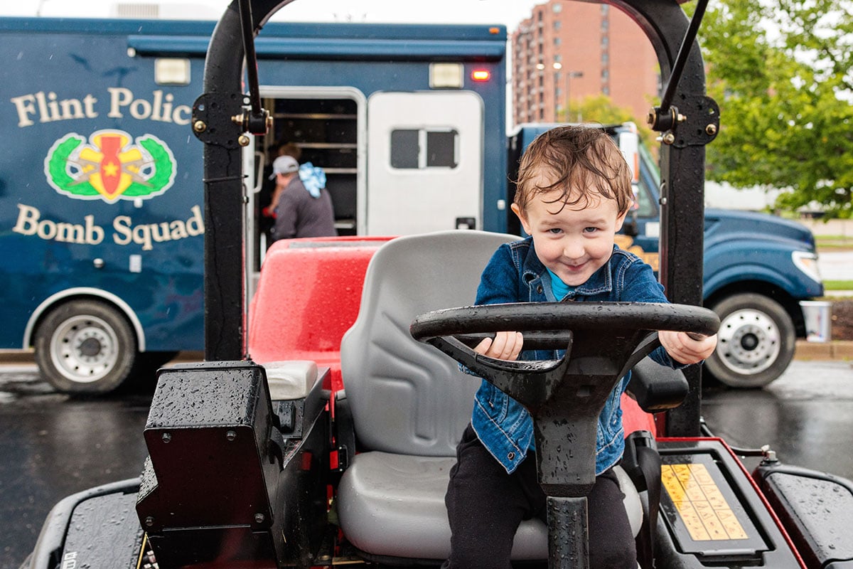 Attendees explore emergency and service vehicles during the University of Michigan-Flint Department of Public Safety Touch-a-Truck event.