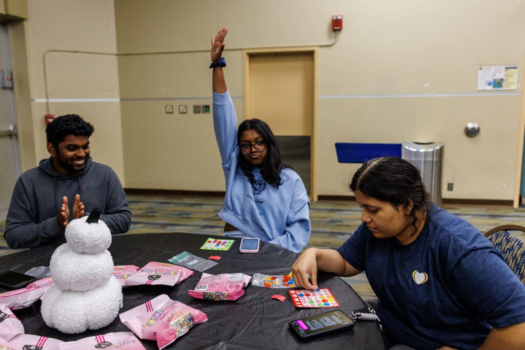 A student raising her hand indicating she got a bingo