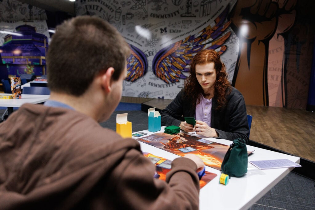 Two students playing a card game in the University Center